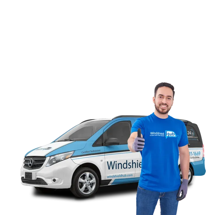 A person holds a large piece of windshield glass. Behind them is a white and blue van with Windshield Hub branding and text that reads Your Local Experts for Auto Glass