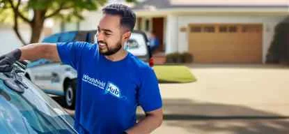 Background image showing a WindshieldHUB service van in a suburban area, representing the company's widespread and accessible auto glass services